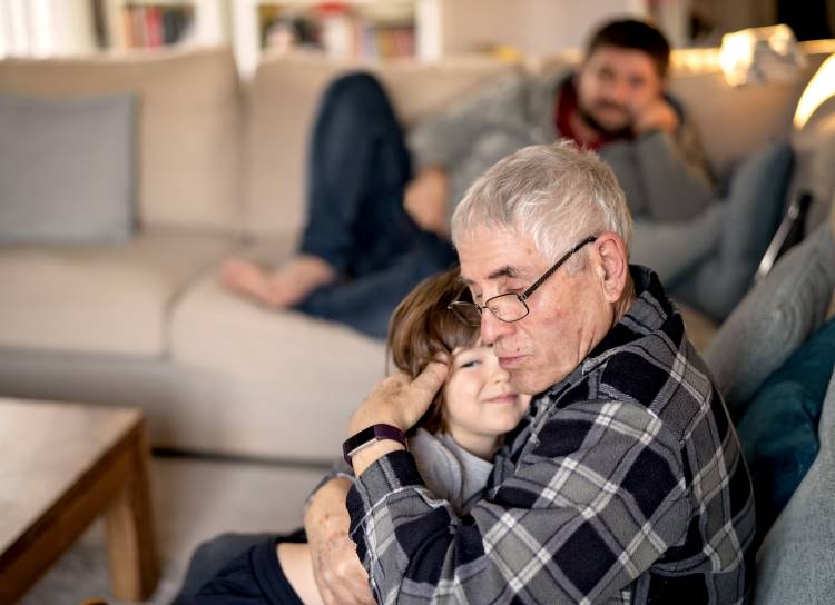 aging parents grandfather hugs child father looks on