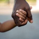 manny kidnapper black hand holding lighter skin child hand