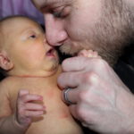 father hold and kissing his daughter on the hand