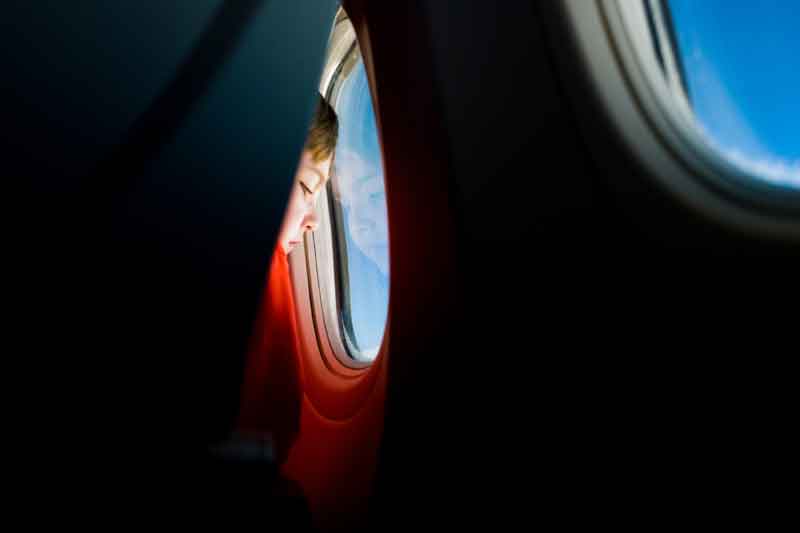 boy looking out plane window