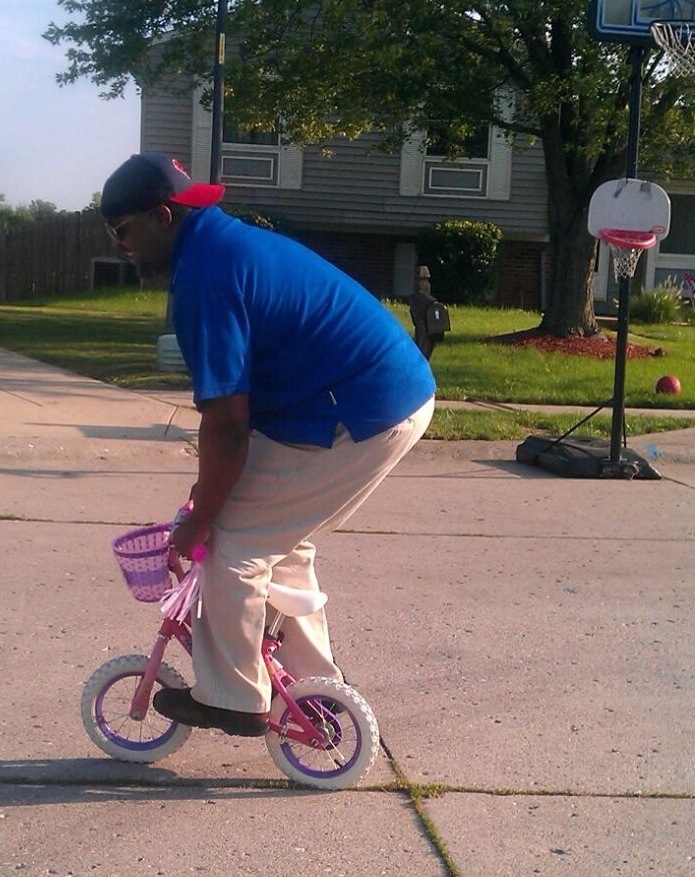 ride a bike Dad on child's bike teaches child to ride a bike