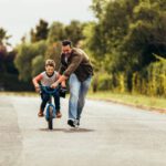 dad help son ride bike 2