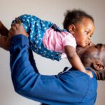 dad raising a daughter for a kiss