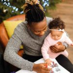 father holds baby while coloring
