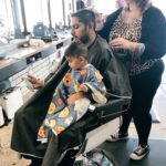 father son get haircuts in same barber chair