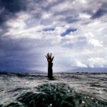 hand reaching out of ocean for help