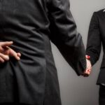 integrity finger crossed behind back shaking hands