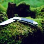 pocket knife on mossy rocks