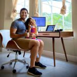 Marlon Gutierrez and his daughter at his remote work station where he works from home in Florida.