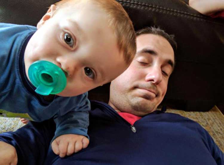 stay-at-home dad sleeps with baby on chest