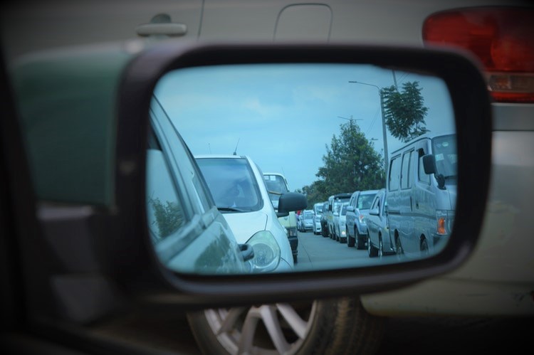 school pickup line traffic jam in car side view mirror