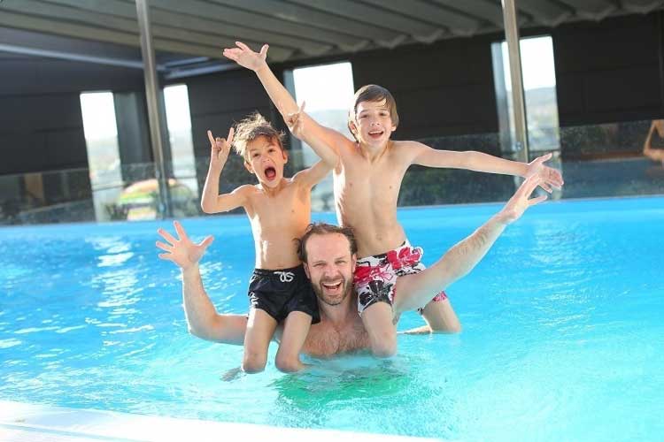 swimming pool dad with kids on shoulders
