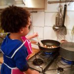 boy stirring pot on stove teaching cooking to children