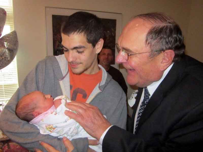 two dads show new baby to grandfather gay parents
